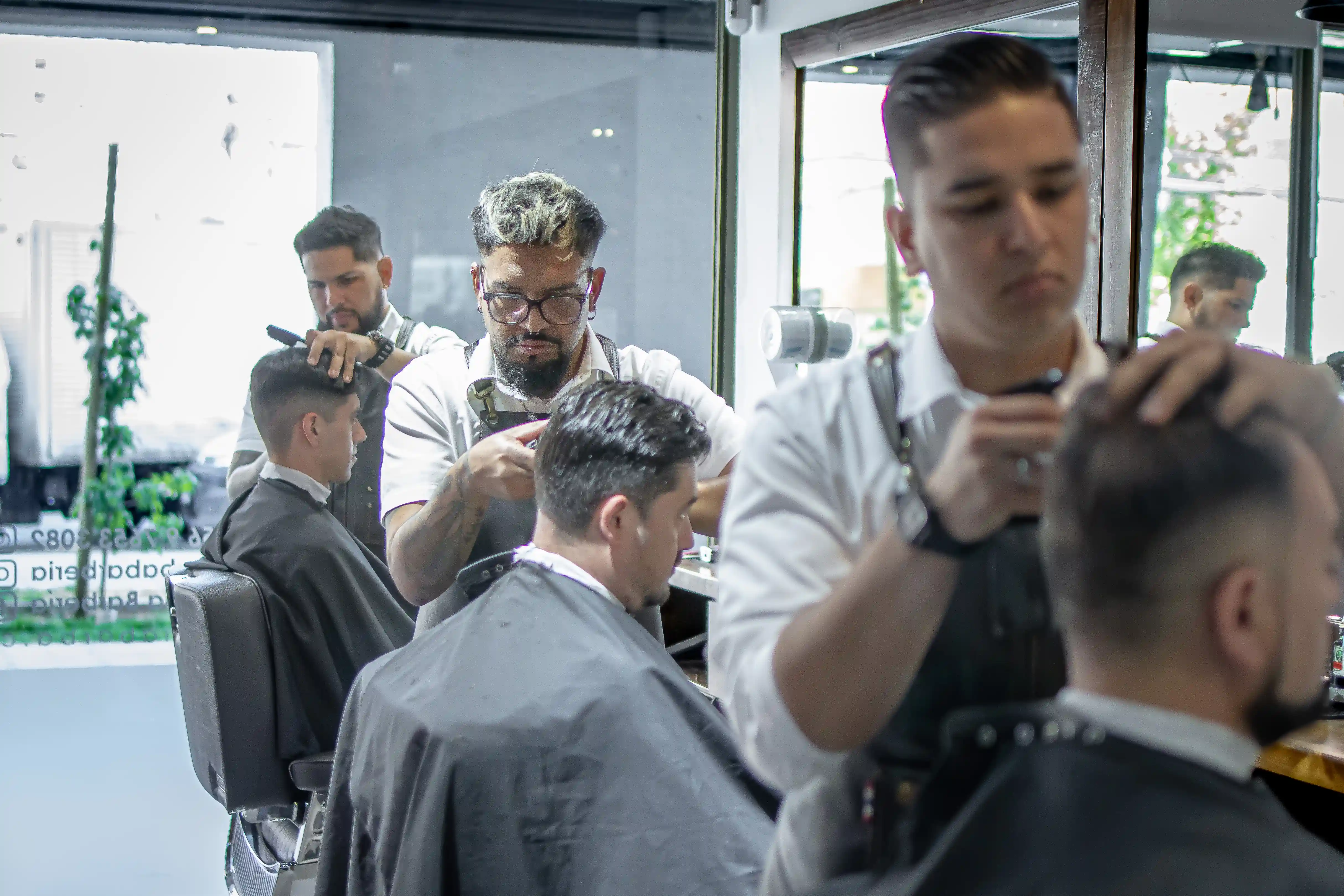 Equipo de barberos trabajando en Buena Barba.